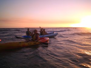 People kayaking on a sunset
