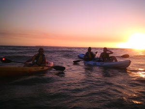 People kayaking on a sunset