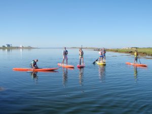 A family enjoying their time on a stand up paddleboard
